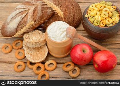 Tasty and healthy products and breads on wooden table