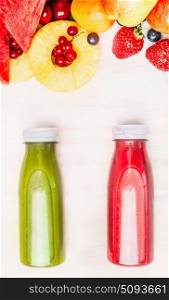 Tasty and healthy summer beverages in bottles with fruits and berries ingredient. Red and green smoothie or juice on white wooden background, top view