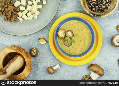 Tasty autumn soup on table. Yummy cream soup from ch&ignon mushrooms.. Bowl with mushroom soup