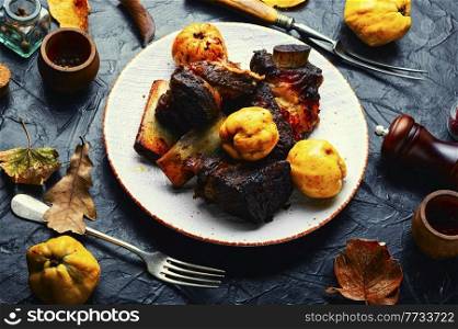 Tasty beef ribs fried with autumn quince.BBQ. Delicious beef ribs fried with fruit