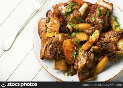 Tasty beef ribs stewed with potatoes.Beef ribs on the plate. Beef ribs stewed with potatoes.