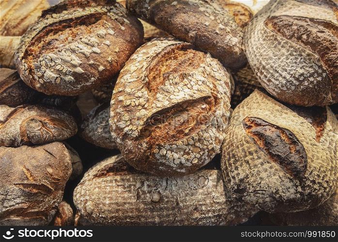 Tasty breads with a golden crust, in a pile, close-up. Rustic breads background. Bakery products context. Freshly baked healthy bread. German bread.