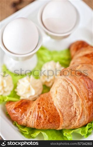 Tasty breakfast from eggs and croissant