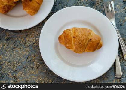 Tasty buttery croissants on old wooden table.