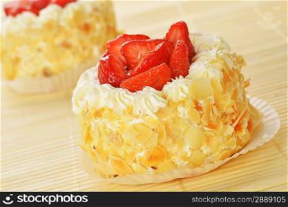 tasty cakes with nuts and strawberries on bamboo table cloth