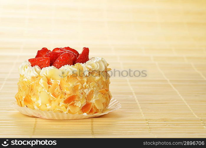 tasty cakes with nuts and strawberries on bamboo table cloth