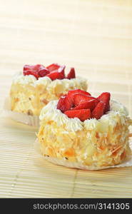 tasty cakes with nuts and strawberries on bamboo table cloth