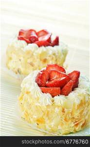 tasty cakes with nuts and strawberries on bamboo table cloth