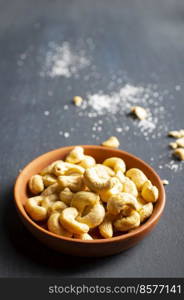 Tasty cashew nuts in bowl on dark table, top view. cashew nuts in bowl on dark table, top view