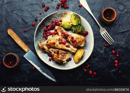 Tasty chicken legs fried with broccoli and cranberries, chicken drumsticks. Juicy chicken drumsticks