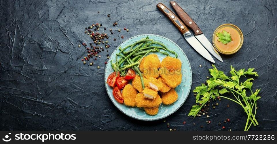 Tasty chicken nuggets with cowpea and tomato.Copy space. Nuggets with vegetable garnish