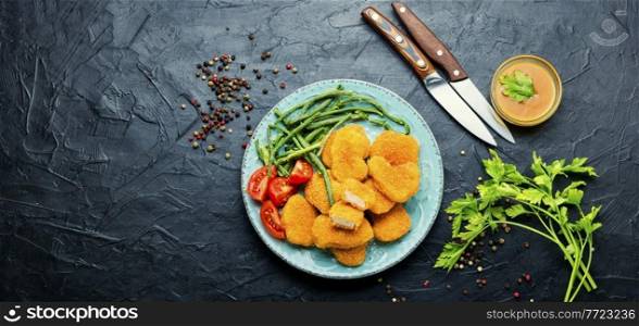 Tasty chicken nuggets with cowpea and tomato.Copy space. Nuggets with vegetable garnish