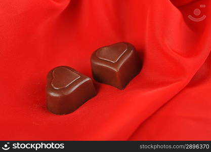 Tasty chocolate on red close up