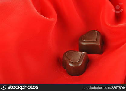 Tasty chocolate on red close up