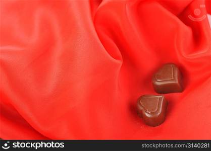 Tasty chocolate on red close up