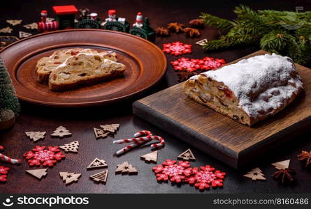 Tasty christmas stollen with marzipans, dried fruits and nuts on a dark concrete background. Tasty christmas stollen with marzipans, dried fruits and nuts