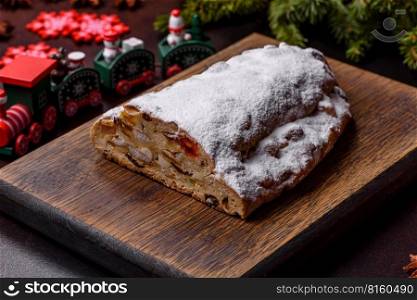 Tasty christmas stollen with marzipans, dried fruits and nuts on a dark concrete background. Tasty christmas stollen with marzipans, dried fruits and nuts