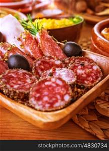 Tasty cold cuts on wooden table at home, slices of salami, pieces of pepperoni and ham, festive menu, different kind of smoked meat
