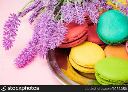 tasty colorful macarons on pink background