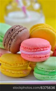 Tasty Colorful macaroons on plate and milk