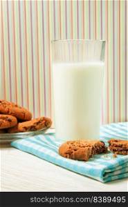 Tasty cookies and glass of milk on white wooden surface and colorful background. Tasty cookies and glass of milk 