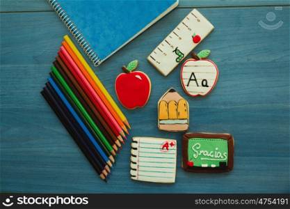 Tasty cookies with shape of school material on a blue wooden background