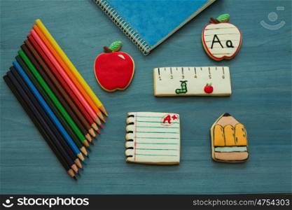 Tasty cookies with shape of school material on a blue wooden background