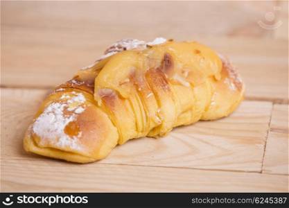 Tasty croissant on a wooden table background