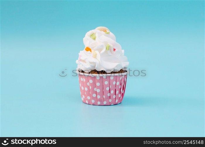 Tasty cup cake on blue background with copy space