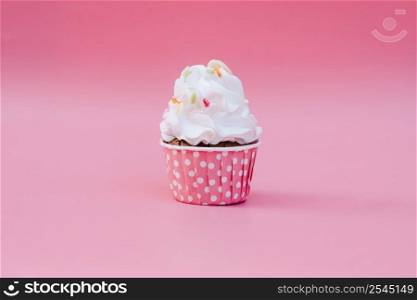 Tasty cup cake on pink background with copy space