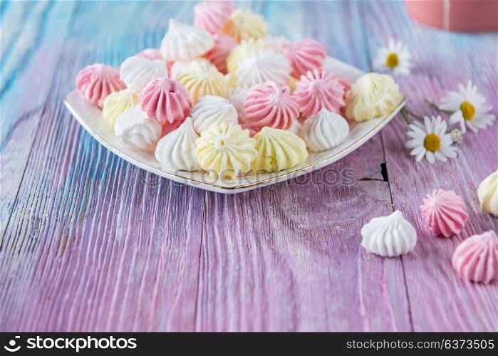 Tasty different marshmallows. Tasty different marshmallows with chamomile flower on a color gradient background