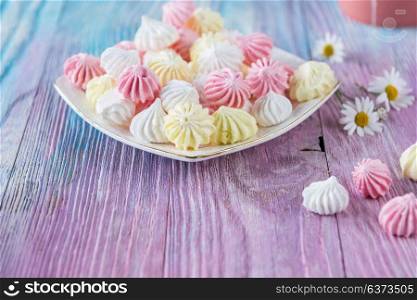 Tasty different marshmallows. Tasty different marshmallows with chamomile flower on a color gradient background