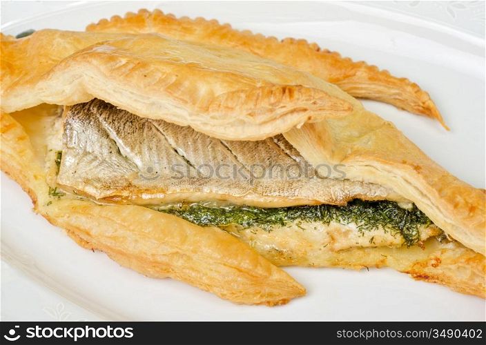 tasty dish of trout fish baked with greens at dough