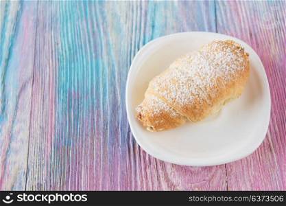 Tasty eclair on plate. Tasty eclair on a color gradient background