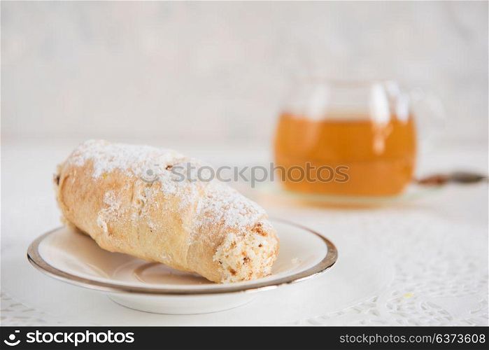 Tasty eclair on plate. Tasty eclair on a white background with tea