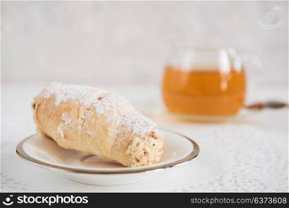 Tasty eclair on plate. Tasty eclair on a white background with tea