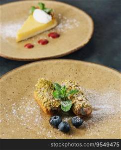 Tasty eclairs with pistachios and cheesecake on plates