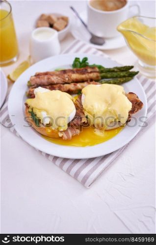 Tasty eggs Be≠dict, hollandaise sauce and aspargus covered with bacon.. Tasty eggs Be≠dict, hollandaise sauce and aspargus covered with bacon