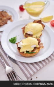 Tasty eggs Benedict, hollandaise sauce and bacon.. Tasty eggs Benedict, hollandaise sauce and bacon