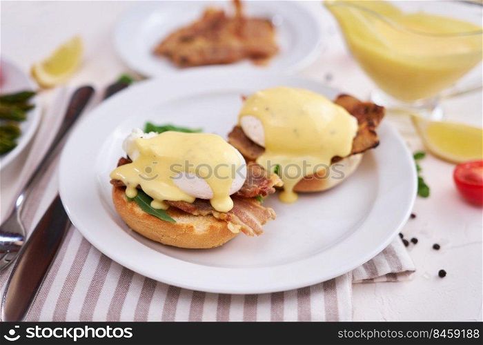 Tasty eggs Benedict, hollandaise sauce and bacon.. Tasty eggs Benedict, hollandaise sauce and bacon