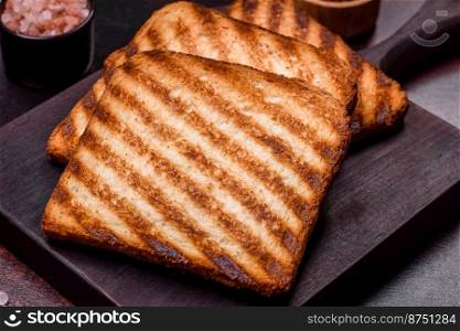 Tasty fresh crispy bread slices in the form of grilled toast for cooking delicious family breakfast. Tasty fresh crispy bread slices in the form of grilled toast