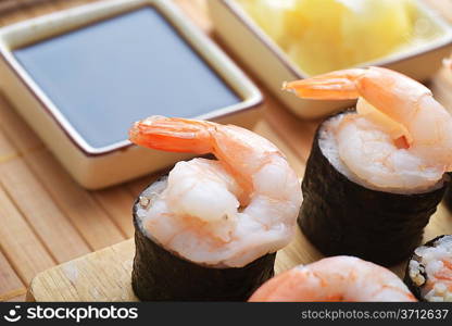 tasty fresh sushi rolls on wooden plate