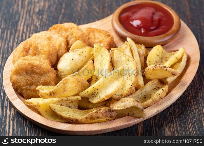Tasty fried nuggets and potatoes on a table. Tasty fried nuggets and potatoes
