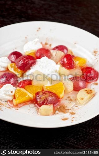 tasty fruit salad of pineapple, grape, orange and strawberry with whipped cream