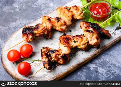 Tasty grilled chicken wings. Chicken wings on barbecue grill,cooked on skewers.American food