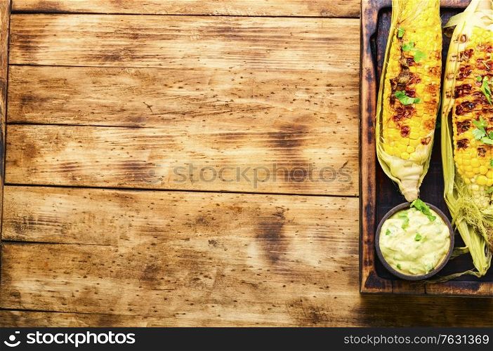 Tasty grilled corn on retro wooden table,summer food.Copy space. Grilled sweet corn cob
