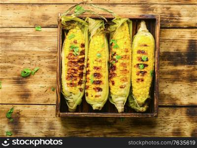 Tasty grilled corn on retro wooden table,summer food. Grilled corn cobs