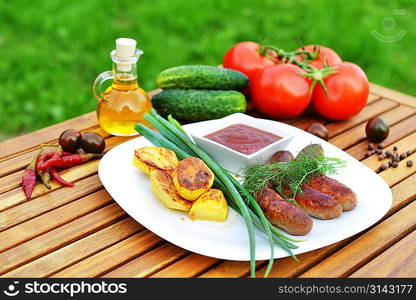 tasty grilled meat sausages on dish and vegetable