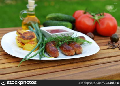 tasty grilled meat sausages on dish and vegetable