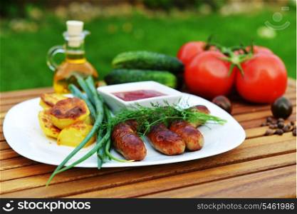tasty grilled meat sausages on dish and vegetable